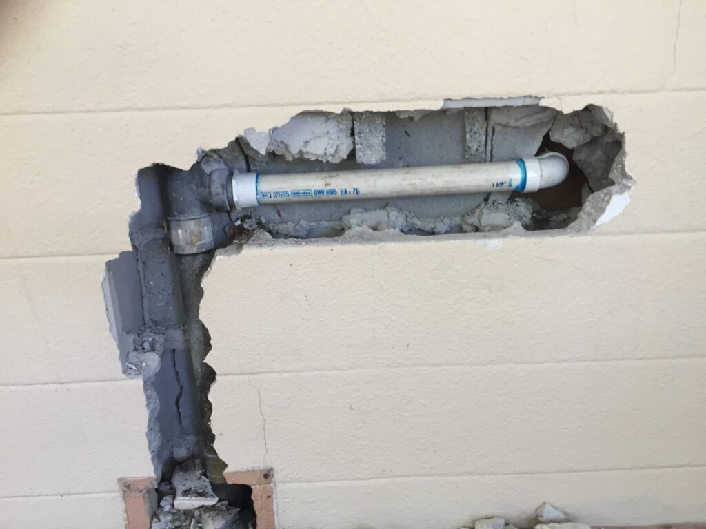 Drain pipe repair through concrete block wall by Massey Plumbing in Dade City, FL