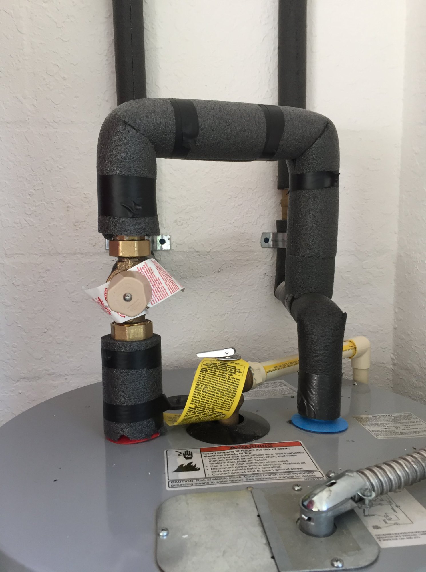 Insulated water heater pipe connections and pressure relief valve by Massey Plumbing in Dade City, FL